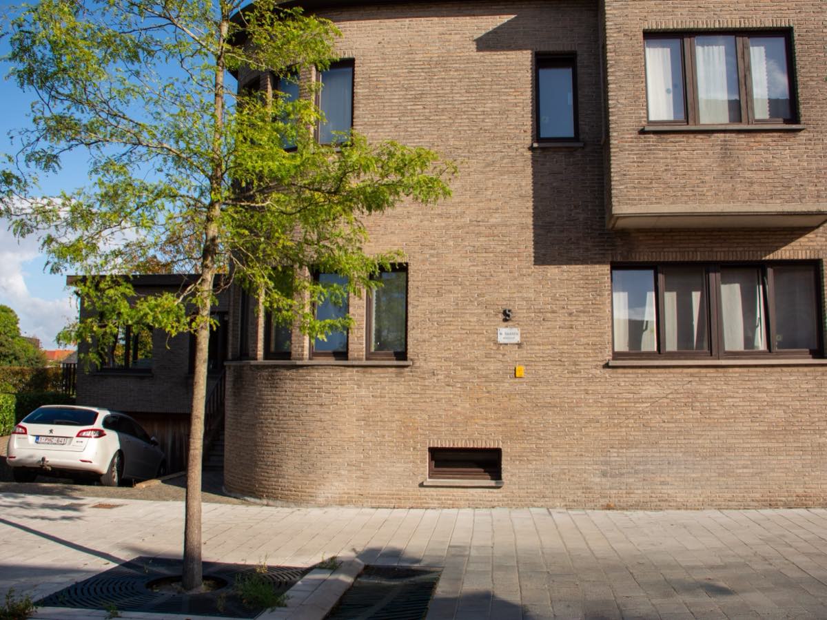 Het kantoorgebouw aan de Fortlaan gezien vanaf de straat, met de boom op de stoep ervoor.