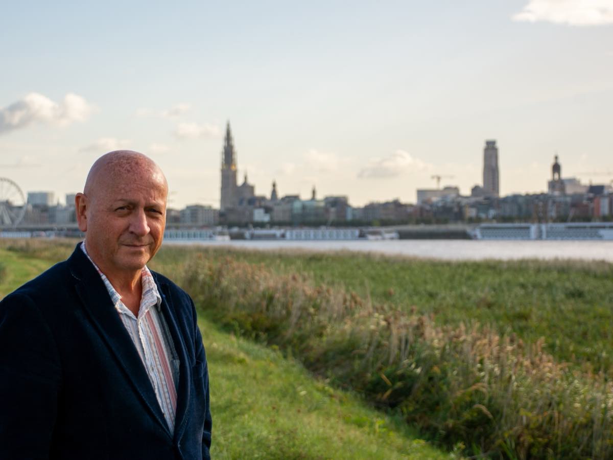 Marc Dassen aan de Schelde in het late namiddaglicht, de Antwerpse kathedraal in de verte.